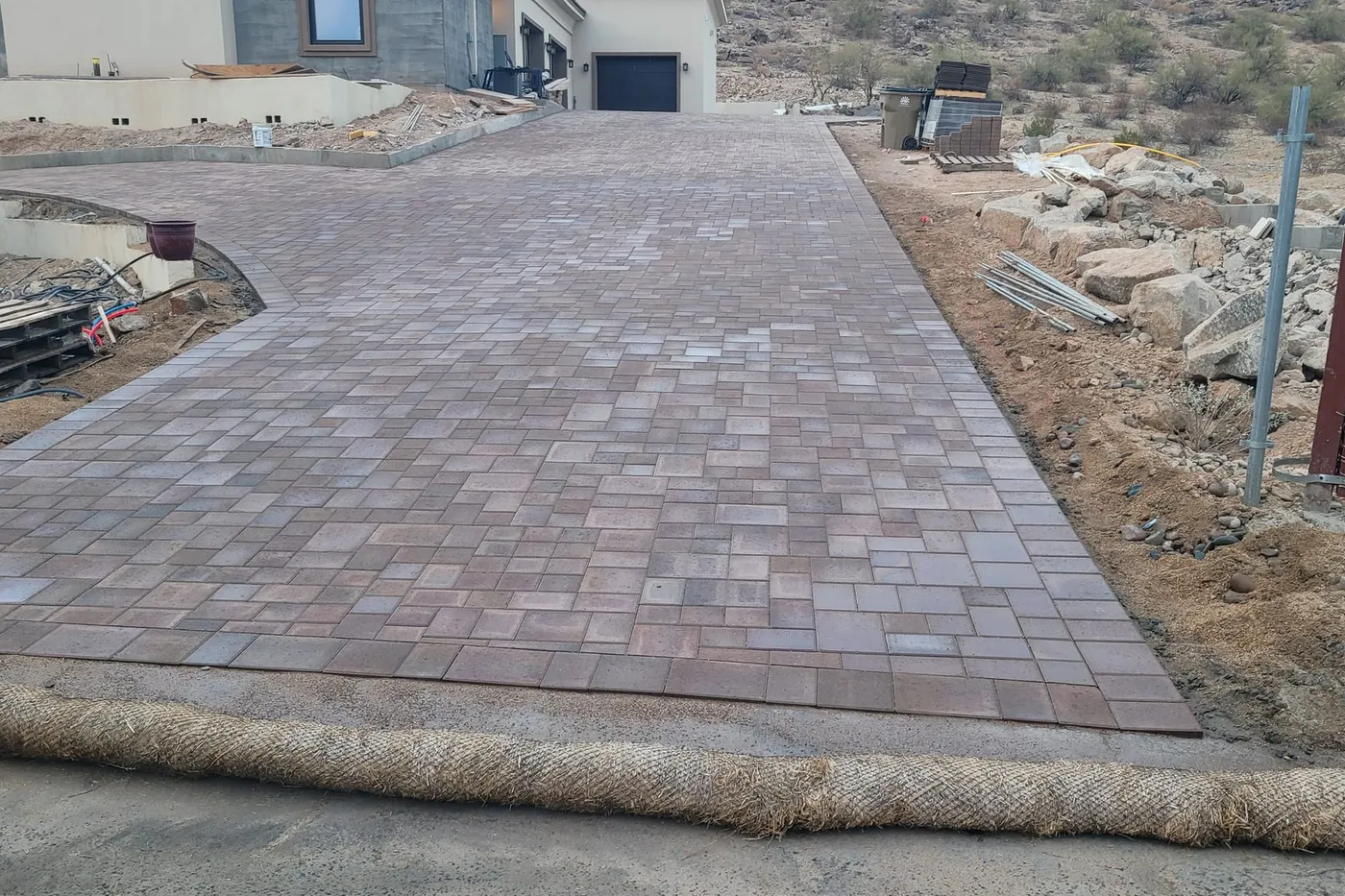 A finished paver driveway leading up to the garage